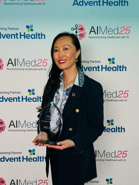 Sherri Douville holding the AIMed 2025 AI Champion Award, Non-Clinician of the Year, at the AIMed25 conference